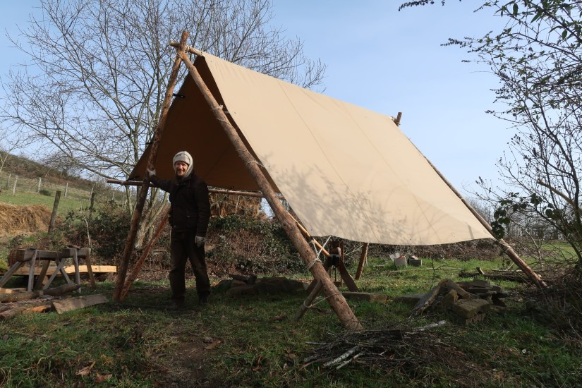 ..working on one of the structures for the roof in the camp..